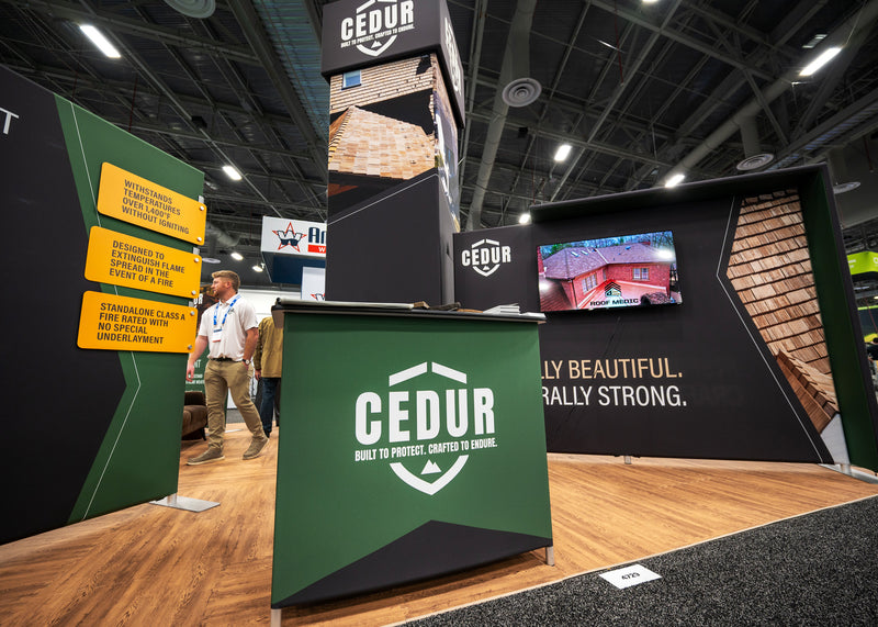 CEDUR booth at a trade show with branding and promotional materials.